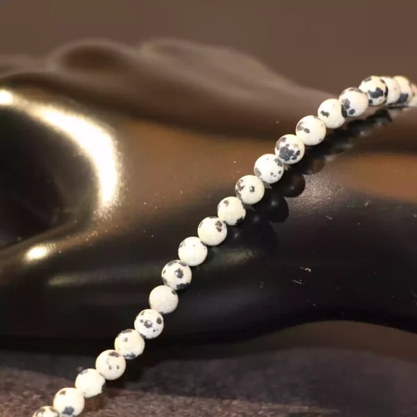 Perles de Jaspe Dalmatien évoquant un ciel étoilé, idéales pour des créations de bijoux uniques avec des perles de 4mm noires et blanches